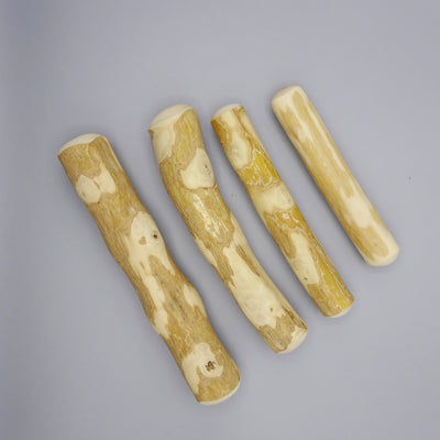 Four coffee wood sticks with natural grain on a gray background