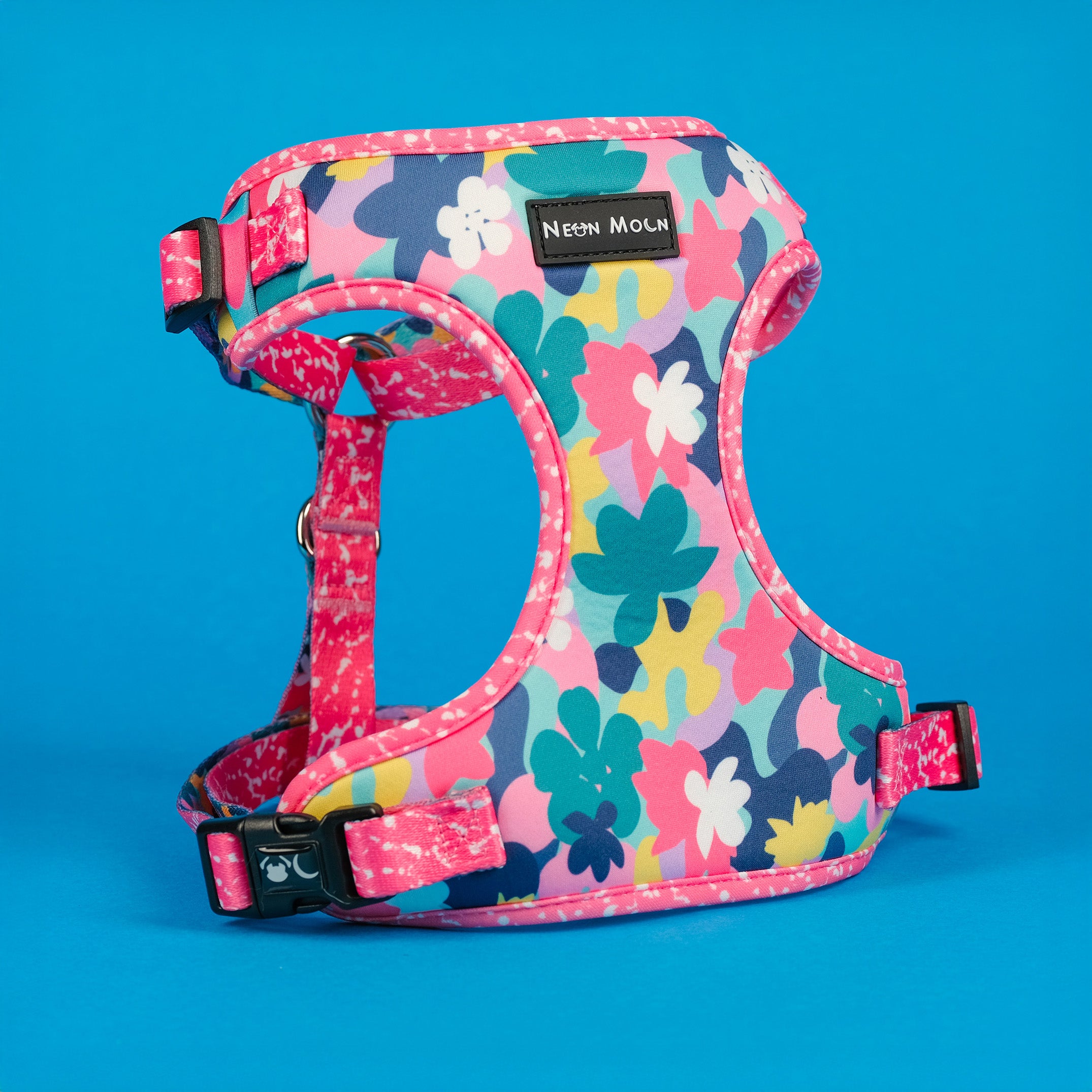 Colorful floral-patterned dog harness on a blue background